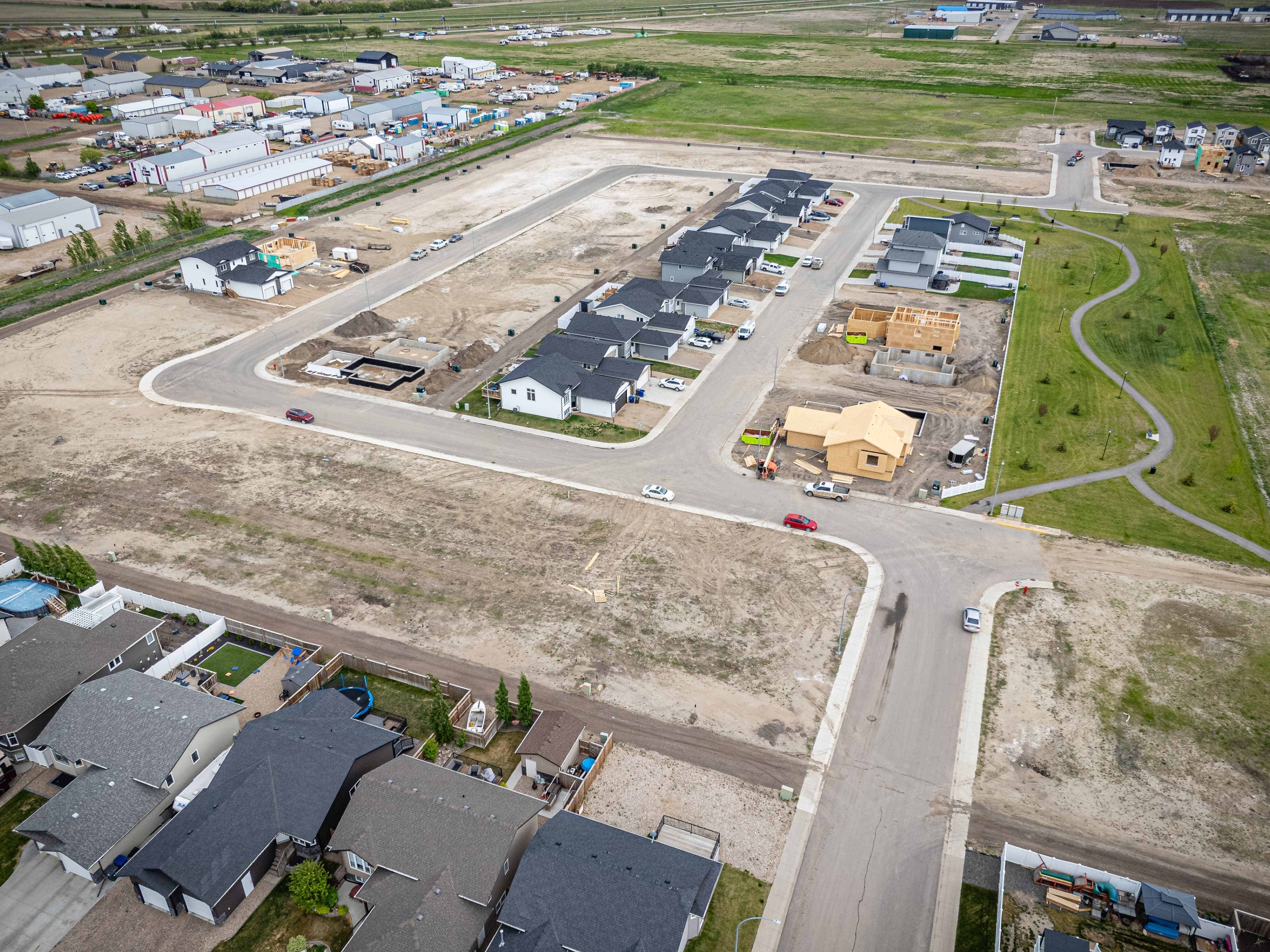 Aerial view of a developing Canadian subdivision with homes and open plots.